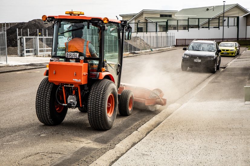 Rear view of a Neilo B3150 Tractor sweeping a dirty road